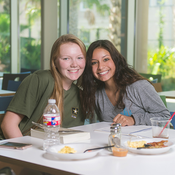 Two girls smiling in the dining hall