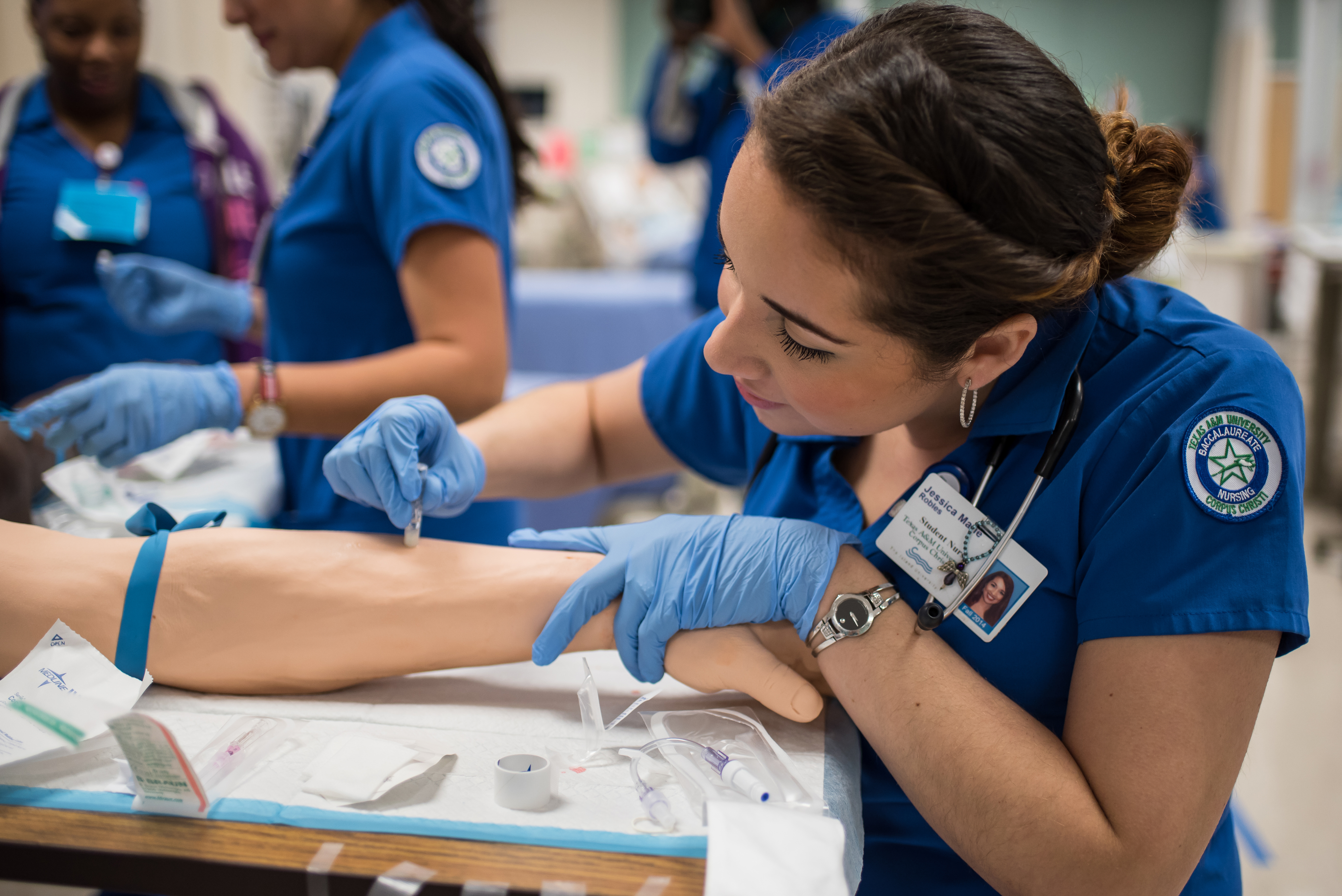 A nurse prepares to give an iv to an outstretched arm