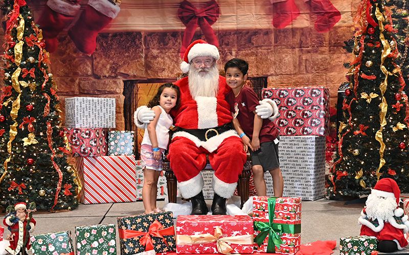 Santa sitting near a fireplace
